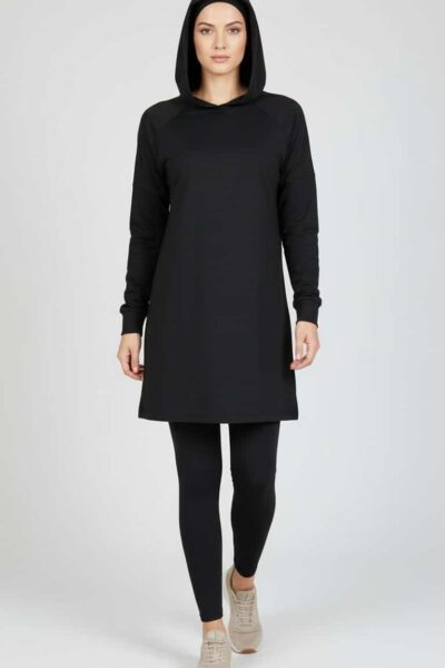 Tunique modeste noire HAYA portée en marche, coupe longue et couvrante, idéale pour la mode modeste féminine.